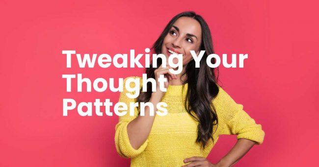 Woman in a yellow knitted top with long brown hair, smiling looking up to her right side. With a thoughtful gesture by holding her right hand to her face. Letters in white writing - Tweaking your thought patterns.